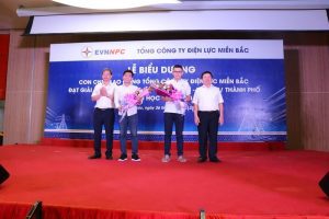 Ông Lê Quang Thái - Phó Tổng giám đốc EVNNPC (bên trái) và ông Nguyễn Văn Tiệp - Chủ tịch công đoàn EVNNPC (bên phải) trao quà tuyên dương cho Nguyễn Hoàng Cường.